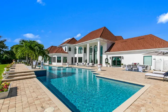 a view of a house with swimming pool and sitting area
