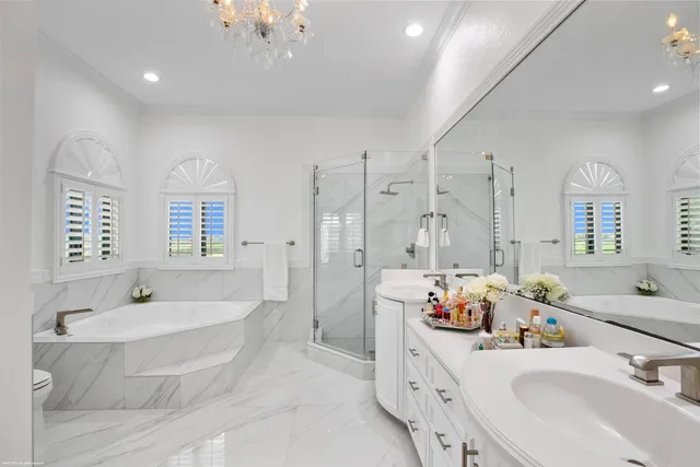a bathroom with double vanity sinks a mirror and a bathtub