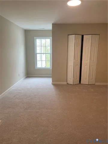 an empty room with windows and closet