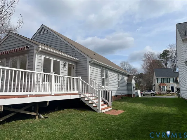 a view of a house with a yard and deck