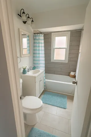 a bathroom with a sink a toilet a window and a mirror