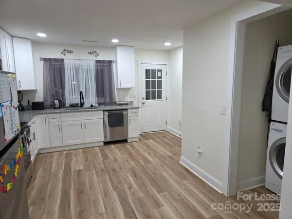 a large kitchen with stainless steel appliances granite countertop a stove a sink and a refrigerator