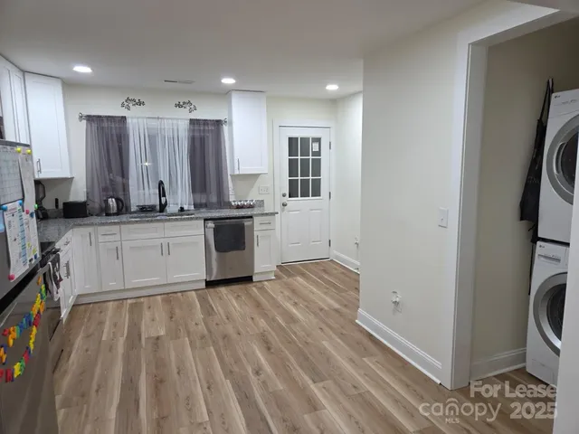 a large kitchen with stainless steel appliances granite countertop a stove a sink and a refrigerator