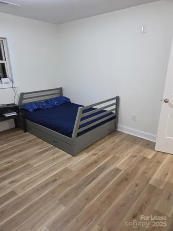 a room with a bed and wooden floor