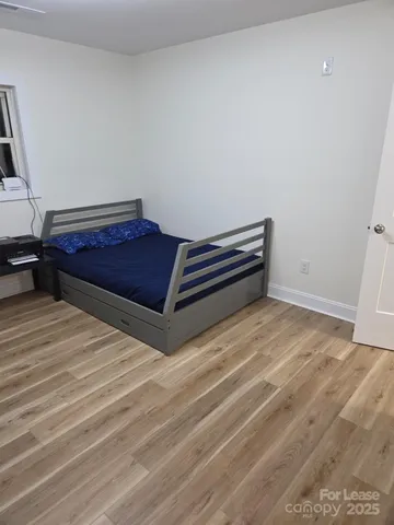 a room with a bed and wooden floor