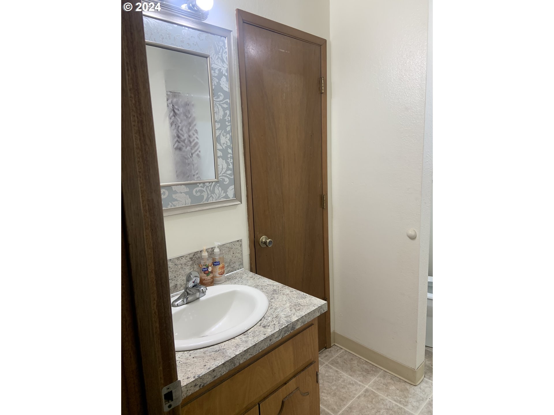 6757 Main Street Springfield, OR 97478 - Photo 9 of 22 a bathroom with a granite countertop sink and a mirror