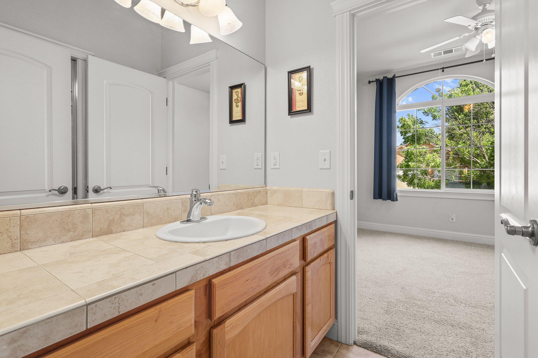 955 Leisha Lane Redding, CA 96001 - Photo 19 of 36 a bathroom with a granite countertop sink and a large mirror