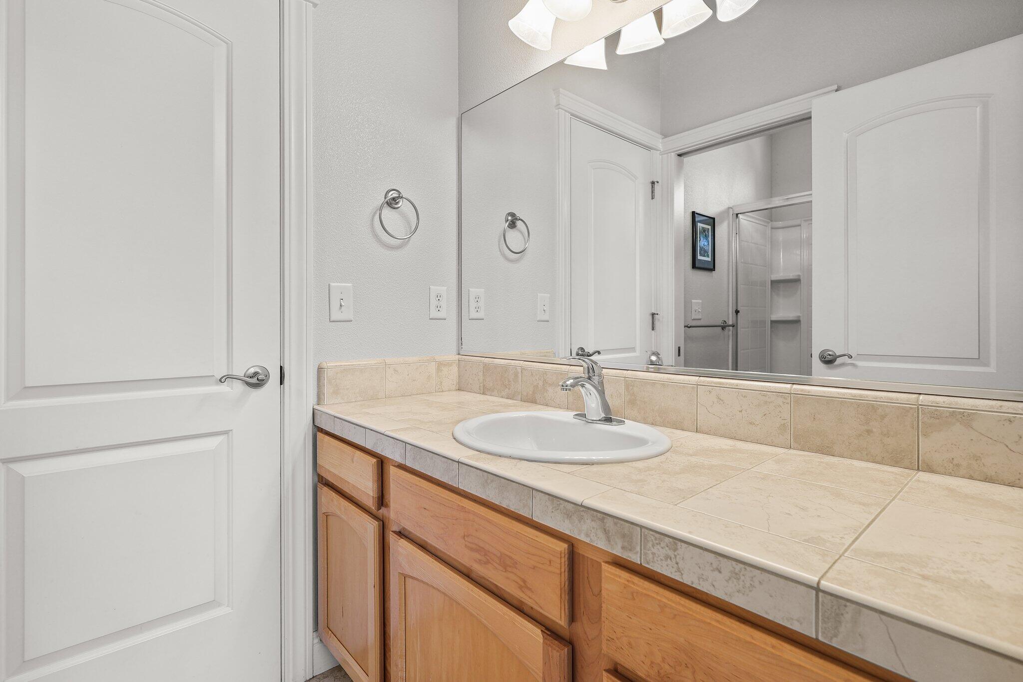 955 Leisha Lane Redding, CA 96001 - Photo 20 of 36 a bathroom with a granite countertop sink and a mirror