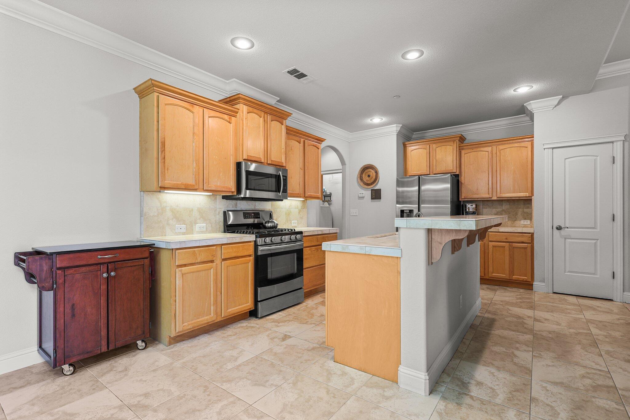 955 Leisha Lane Redding, CA 96001 - Photo 3 of 36 a kitchen with stainless steel appliances granite countertop a stove top oven a sink dishwasher a refrigerator and cabinets with wooden floor