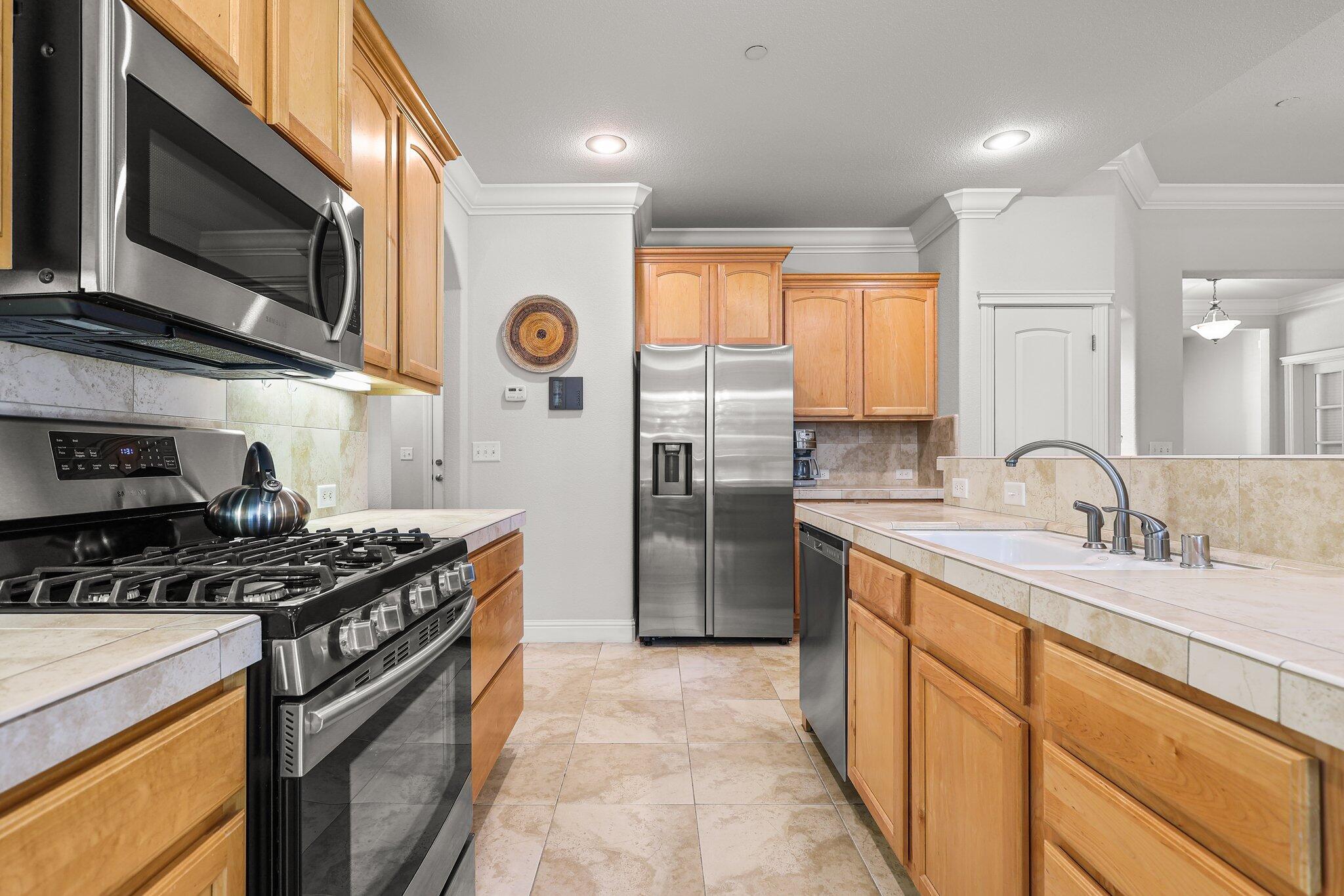 955 Leisha Lane Redding, CA 96001 - Photo 4 of 36 a kitchen with stainless steel appliances granite countertop a stove a sink and a refrigerator