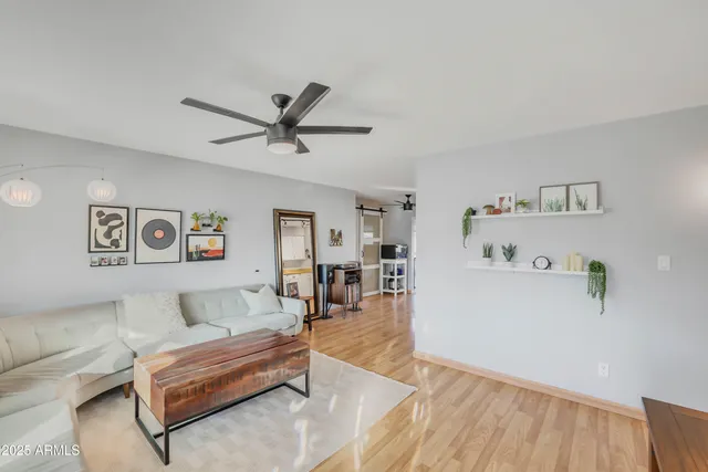 a living room with furniture and a dining table with wooden floor