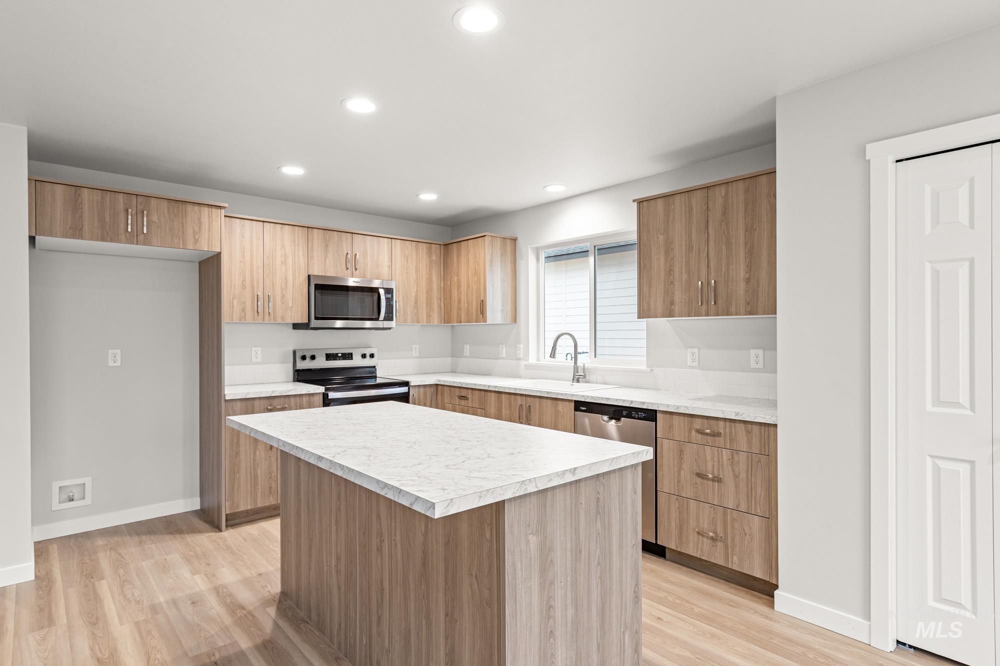 4287 South Red Sox Way Nampa, ID 83686 - Photo 4 of 22 Kitchen featuring light countertops, stainless steel appliances, light wood-style flooring, a kitchen island, and recessed lighting