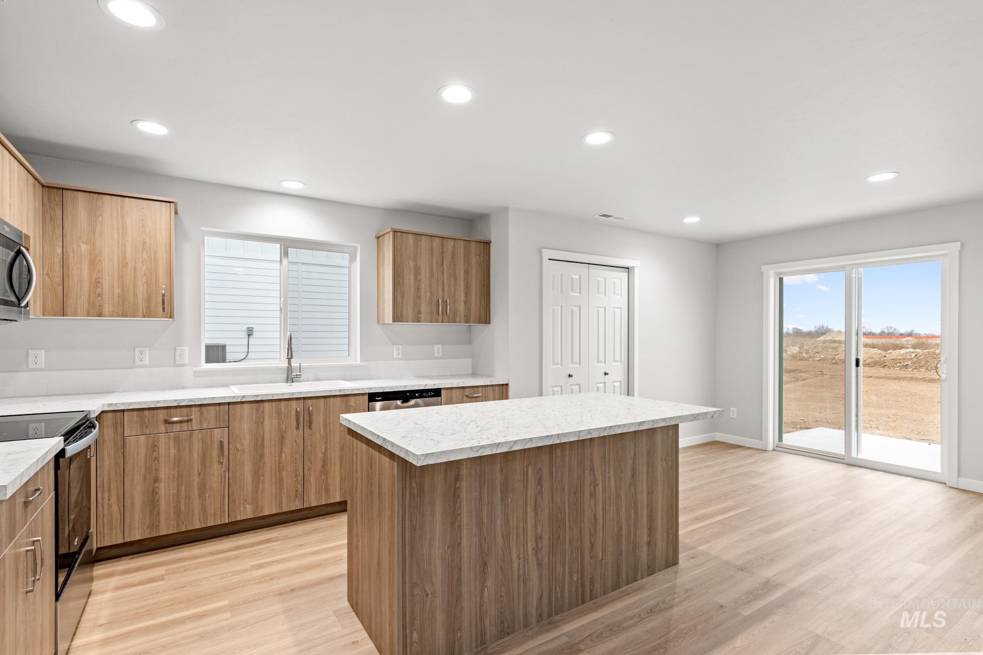 4287 South Red Sox Way Nampa, ID 83686 - Photo 7 of 22 Kitchen with appliances with stainless steel finishes, a center island, recessed lighting, light wood-style floors, and plenty of natural light