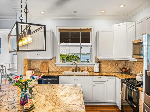 a kitchen with stainless steel appliances granite countertop a stove a sink and a microwave