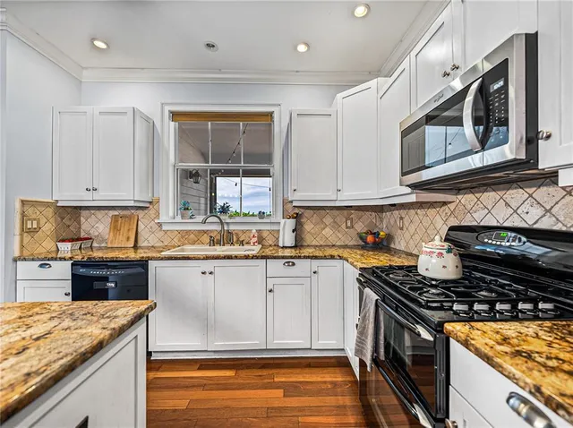 a kitchen with stainless steel appliances granite countertop a stove and a sink