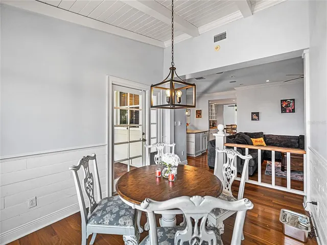 a living room with furniture a dining table and a chandelier