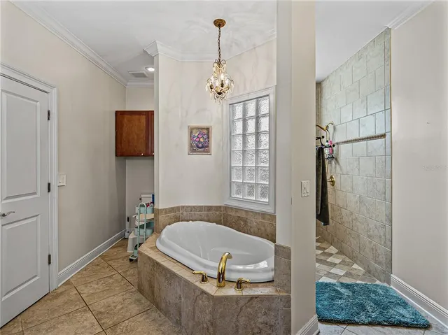 a bathroom with a tub a window and a shower