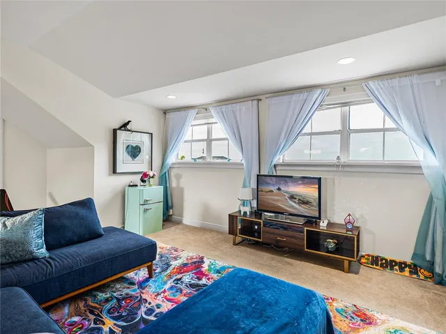 a living room with furniture a flat screen tv and a window