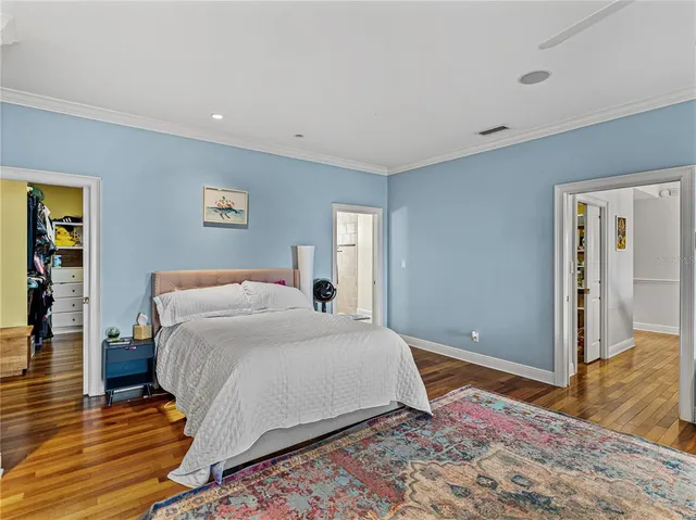 a bedroom with a bed and a painting on the wall