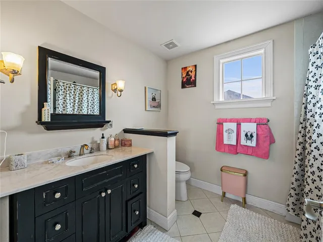 a bathroom with a toilet sink vanity and mirror