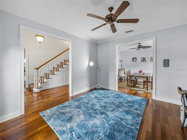 a view of a livingroom with wooden floor and a ceiling fan