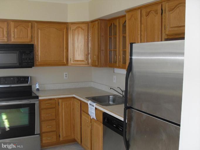 2407 Carrollton Road Finksburg, MD 21048 - Photo 8 of 25 a kitchen with a refrigerator and cabinets