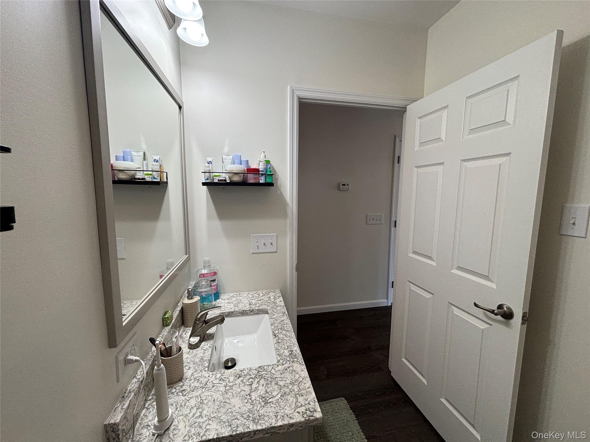 1661 Old Country Road, Unit 563 Riverhead, NY 11901 - Photo 19 of 43 a bathroom with a sink and mirror