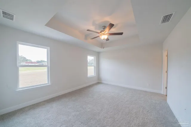 an empty room with a window and a fan
