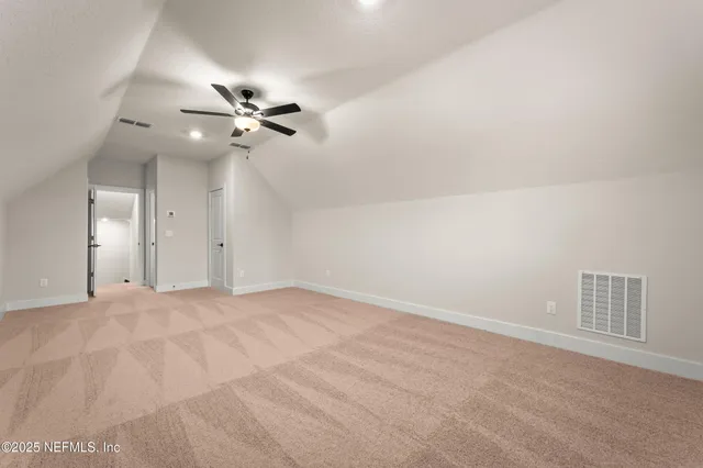 en empty room with ceiling fan and window