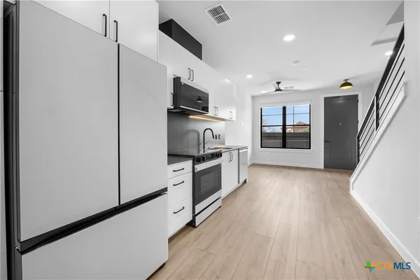 a kitchen with stainless steel appliances a refrigerator and a stove top oven