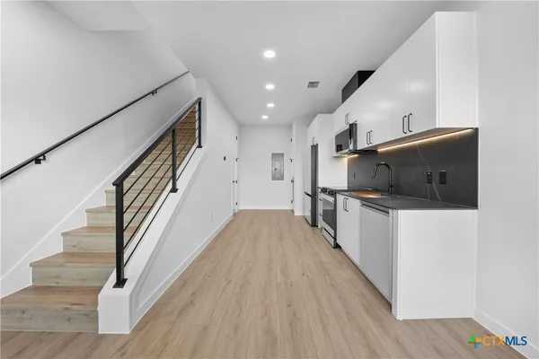 a view of a hallway with wooden floor