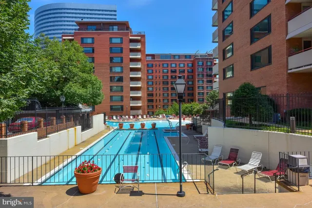 a view of a swimming pool with a patio and fire pit