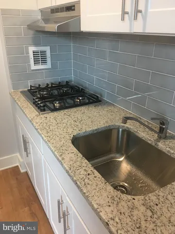 a kitchen with a sink and a stove top oven