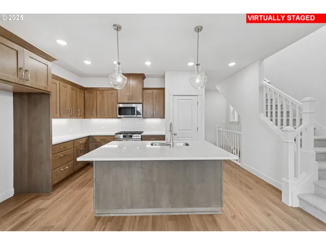 a open kitchen with kitchen island a sink dishwasher a refrigerator and a stove with wooden floor