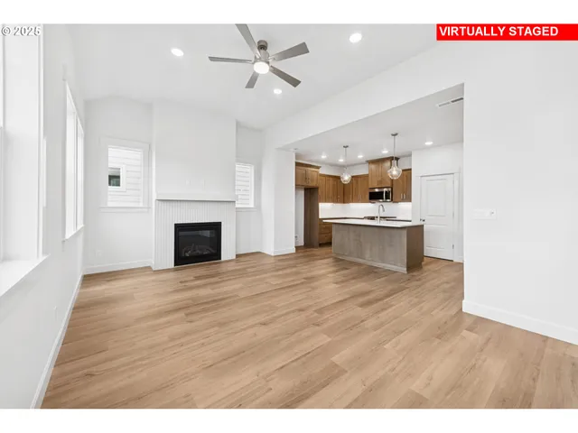a view of kitchen and empty room with wooden floor