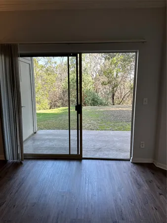 a view of empty room with wooden floor and door