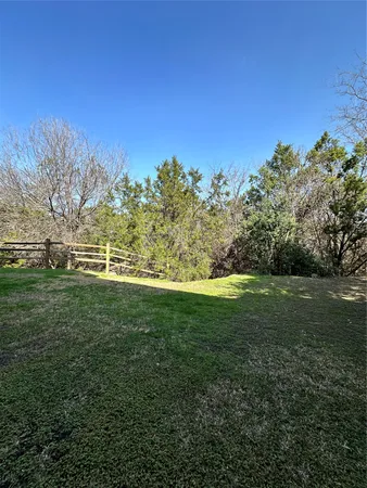 a view of a field with grass and trees