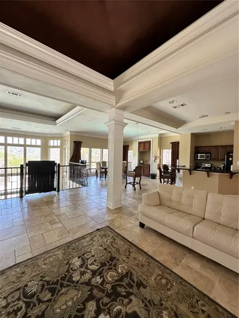 a living room with couches and kitchen view with wooden floor