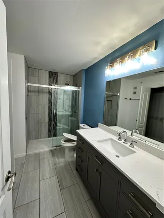 a bathroom with a double vanity sink toilet and shower