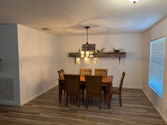 a view of a dining room with furniture wooden floor and chandelier