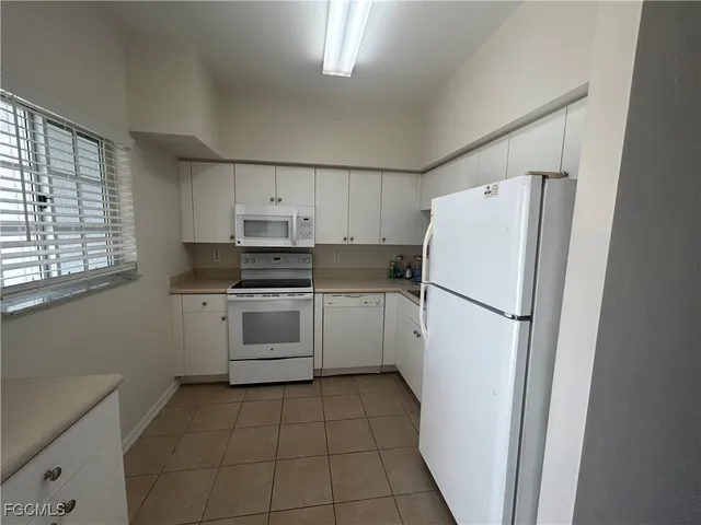 a kitchen with a refrigerator sink washer and dryer