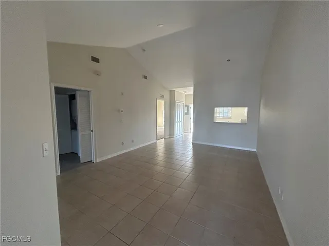 a view of a hallway with wooden floor and windows