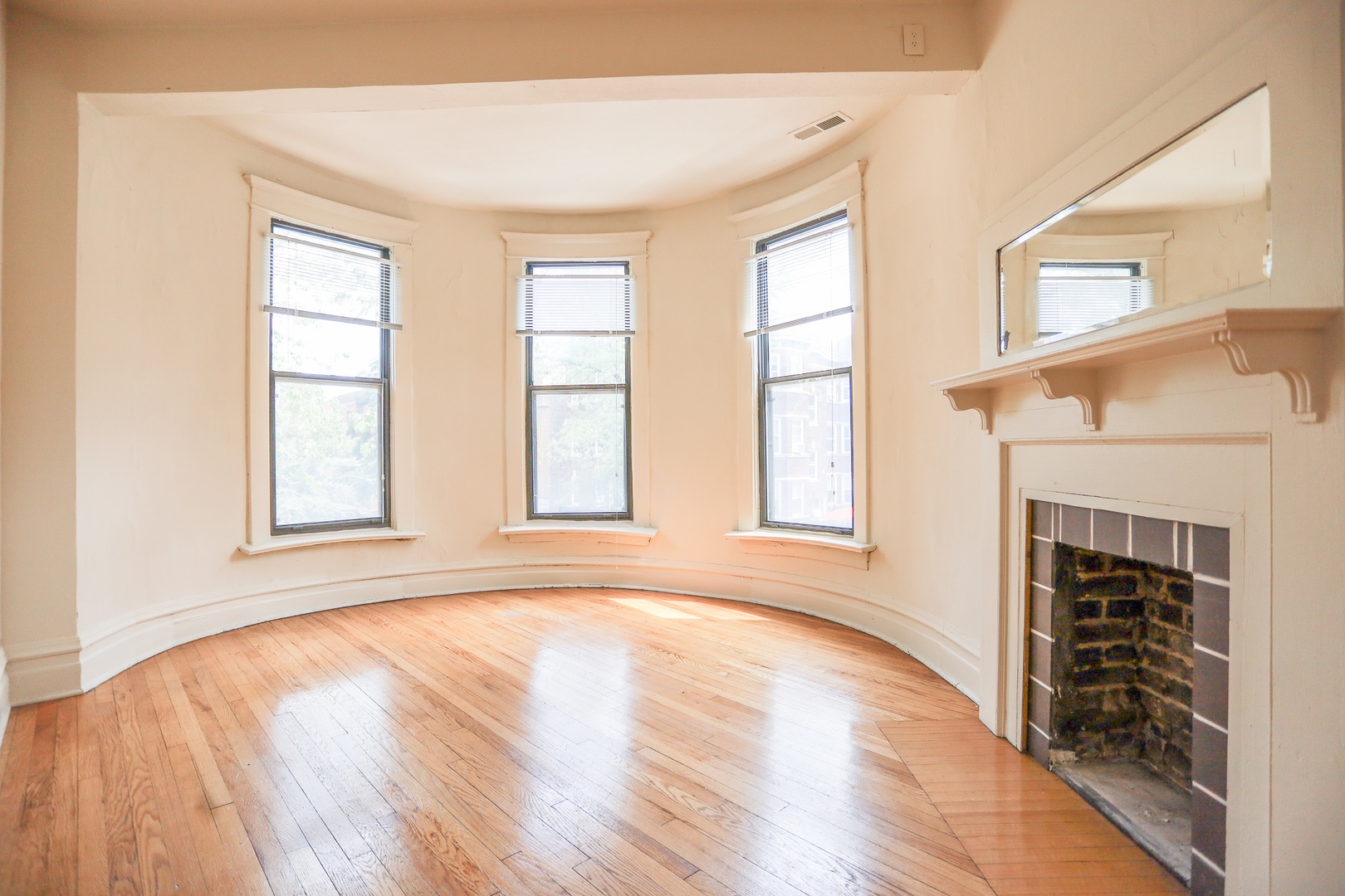 3500 North Reta Avenue, Unit 2 Chicago, IL 60657 - Photo 2 of 12 an empty room with wooden floor fireplace and windows