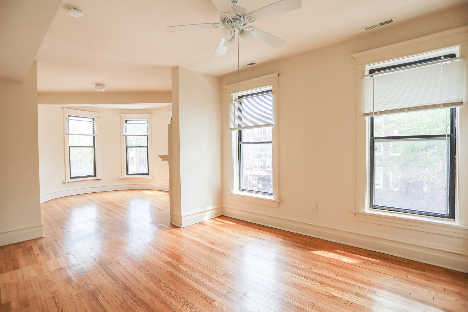 3500 North Reta Avenue, Unit 2 Chicago, IL 60657 - Photo 4 of 12 an empty room with wooden floor chandelier and windows
