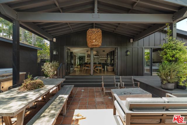 a backyard of a house with barbeque oven and outdoor seating