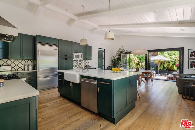 a kitchen with a table chairs and wooden floor