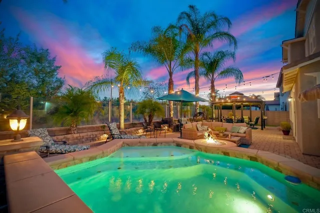 a view of a house with swimming pool and sitting area