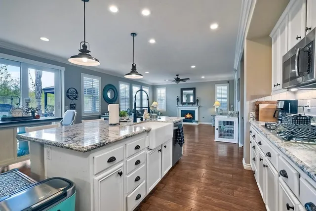 a large bathroom with a granite countertop double vanity sink a mirror and a bathtub