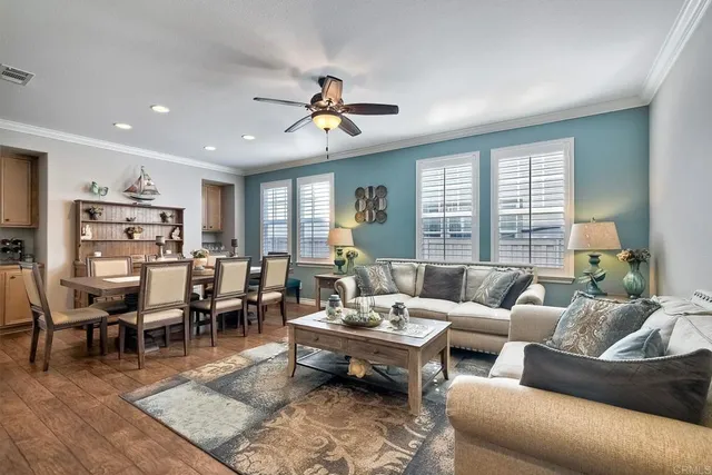 a living room with furniture a clock potted plant and a window