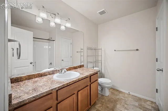 a bathroom with a granite countertop sink a toilet and mirror